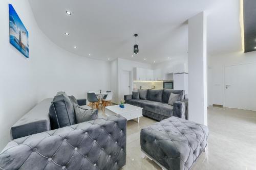 a living room with two couches and a table at Lux DAM Apartments in Bar