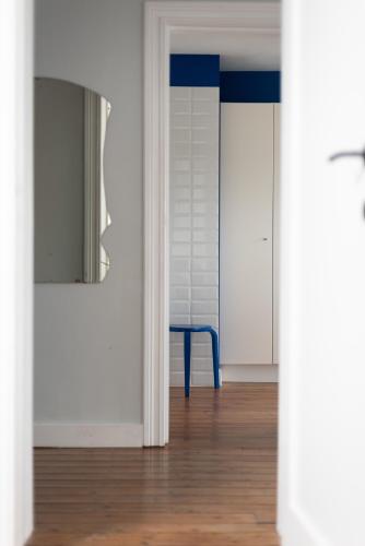 a room with a blue chair and a mirror at Townhouse Tongeren Center - Featured in Designbook in Tongeren