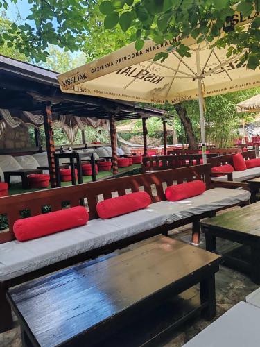 a group of benches with red pillows on them at Pansion Oscar Summer Garden in Mostar