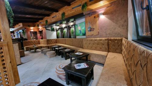 a restaurant with a couch and tables in a room at Pansion Oscar Summer Garden in Mostar