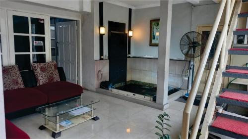 a living room with a couch and a fireplace at JALA GUEST HOUSE near JUANDA AIRPORT in Sawotratap