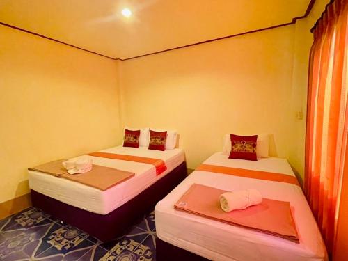 two beds in a small room with two at Baan Klong House in Baan Khai