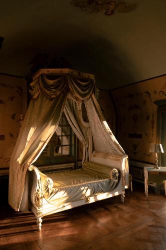 a bedroom with a canopy bed with a window at Le château de Bonnemare - Bed and breakfast in Radepont