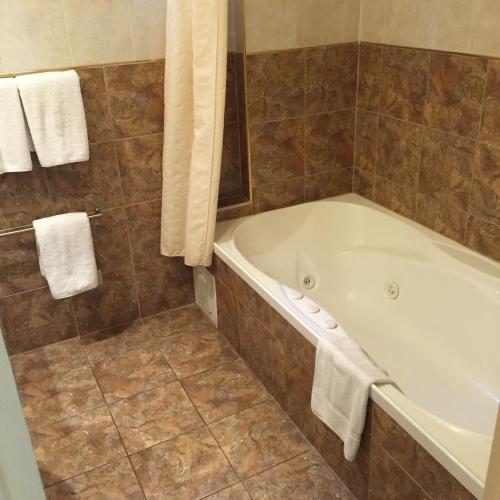 a bathroom with a bath tub and towels at Criterion Hotel-Motel Rockhampton in Rockhampton