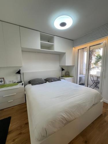 um quarto com uma grande cama branca e uma janela em T2 Neuf Hyper centre ville Sanary em Sanary-sur-Mer