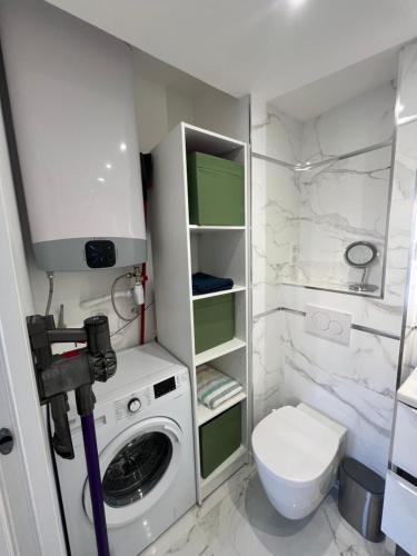uma casa de banho com uma máquina de lavar roupa e um WC em T2 Neuf Hyper centre ville Sanary em Sanary-sur-Mer