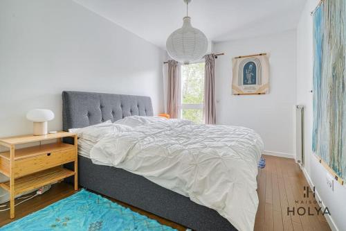 - une chambre avec un lit, une table de chevet et une fenêtre dans l'établissement À deux pas de Paris - Le Convivial - 105MB, à Rueil-Malmaison