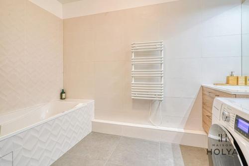 une salle de bain blanche avec une baignoire et un lavabo dans l'établissement À deux pas de Paris - Le Convivial - 105MB, à Rueil-Malmaison