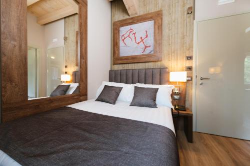 a bedroom with a large bed and a mirror at Lake Hotel La Pieve in Pisogne