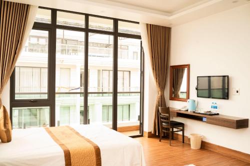 a hotel room with a bed and a large window at Lux Hotel FLC Sầm Sơn in Sầm Sơn