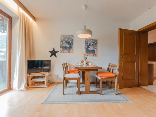 een eetkamer met een tafel en stoelen en een tv bij Apartment Bella Vista by Interhome in Bad Hofgastein