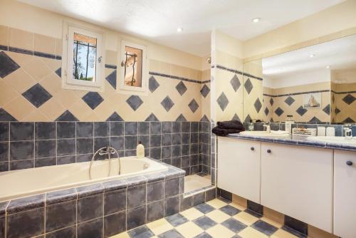 une salle de bain avec une baignoire et un lavabo dans l'établissement Maison - La Lieutenante, à Puget-sur Argens