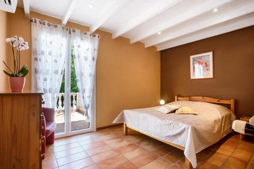 une chambre avec un lit et une grande fenêtre dans l'établissement Maison - La Lieutenante, à Puget-sur Argens