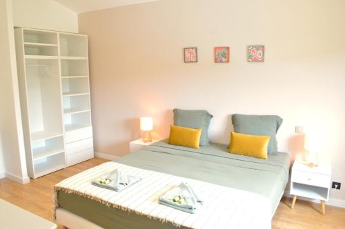 une chambre avec un grand lit avec des oreillers jaunes dans l'établissement Villa 5 suites et piscine à Mougins, à Mougins