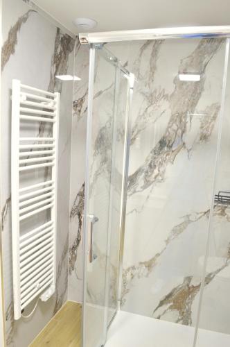 La salle de bains est pourvue d'une douche et d'un mur en marbre. dans l'établissement Villa 5 suites et piscine à Mougins, à Mougins