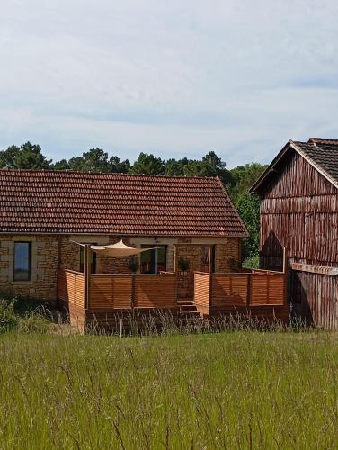 une maison avec un porche avec un parapluie dans un champ dans l'établissement Douceur de vivre à Sarlat, à Sarlat-la-Canéda