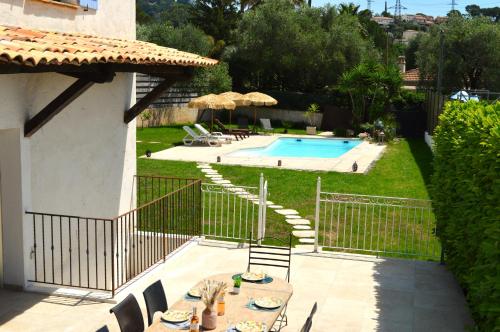 un patio avec une table et des chaises à côté d'une piscine dans l'établissement Villa 5 suites et piscine à Mougins, à Mougins