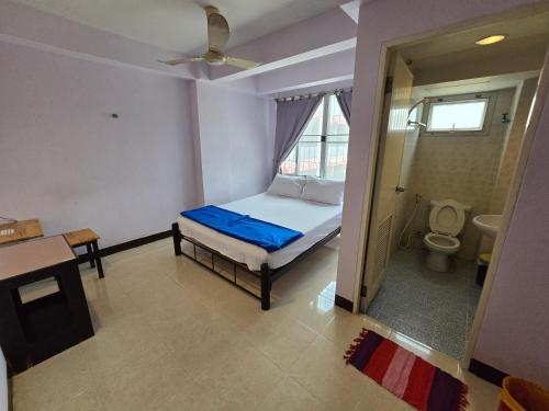a small bedroom with a bed and a toilet at Bella Bella Riverview in Bangkok