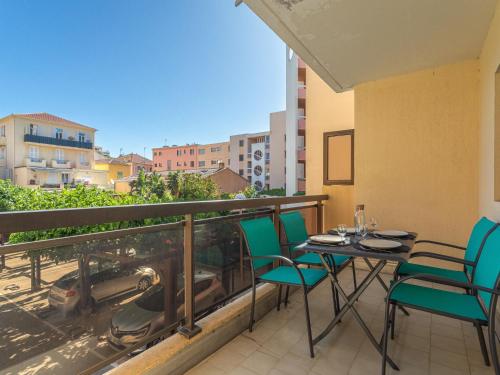 Un patio con una mesa y sillas en un balcón. en Apartment Saint James-3 by Interhome, en Le Lavandou