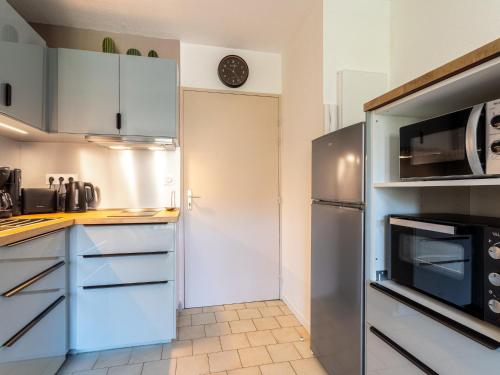  La cuisine est équipée de placards blancs et d'un réfrigérateur. dans l'établissement Apartment Saint James-3 by Interhome, au Lavandou