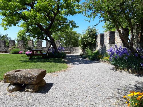 a stone bench in a garden with flowers at Apartment di Magnano by Interhome in Diolo