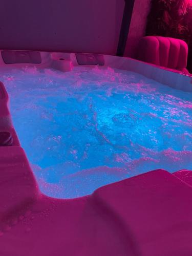 un jacuzzi avec de l'eau bleue et des lumières roses dans l'établissement Chill N Love prox EuropaPark et Rulantica Strasbourg Colmar, à Rossfeld