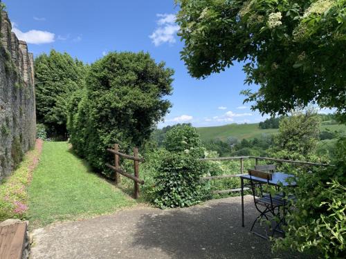 a garden with a fence and a table and trees at Apartment di Magnano by Interhome in Diolo
