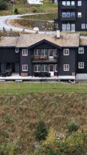 a large brown house with a large yard at Voss Resort self-service apartments in Skulestadmo