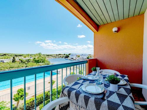a table on a balcony with a view of the water at Apartment Les Barcarelles by Interhome in Le Barcarès