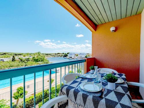 une table sur un balcon avec vue sur l'eau dans l'établissement Apartment Les Barcarelles by Interhome, au Barcarès