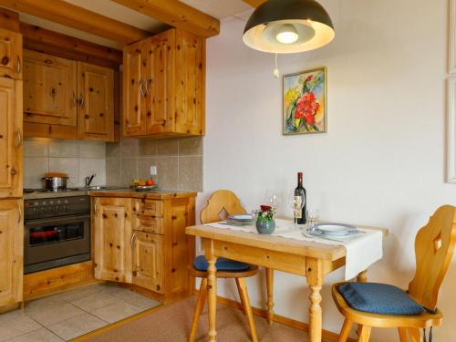 een keuken met houten kasten en een tafel en stoelen bij Apartment Residenza Chesa Margun 57-2 by Interhome in Surlej