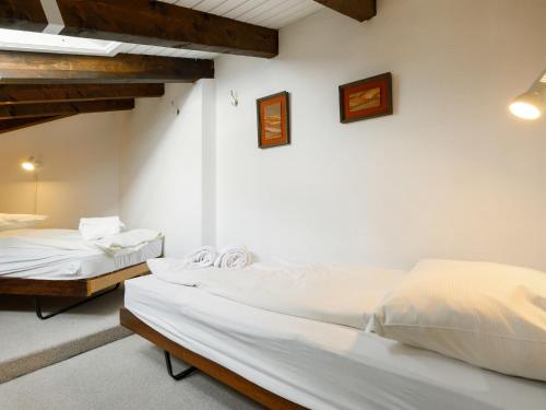 two beds in a room with white walls at Apartment Residenza Chesa Margun 15-1 by Interhome in Surlej
