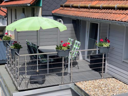 einen Balkon mit 2 Stühlen und einem Sonnenschirm in der Unterkunft Ferienwohnung Am Graben in Hasselfelde