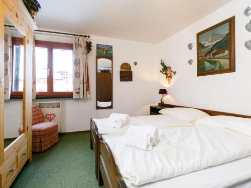 a bedroom with two beds and a chair at Apartment Residenza Chesa Margun 13-5 by Interhome in Surlej
