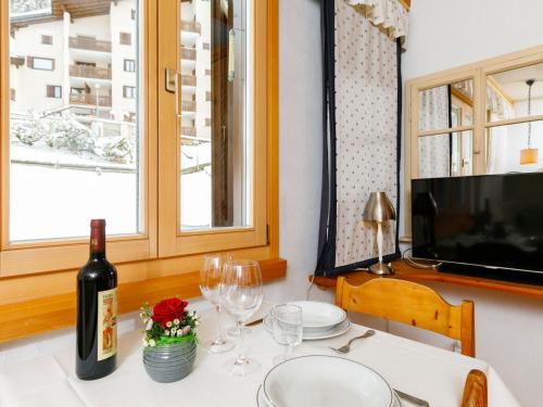 a table with a bottle of wine and glasses at Studio Residenza Chesa Margun 34-4 by Interhome in Surlej