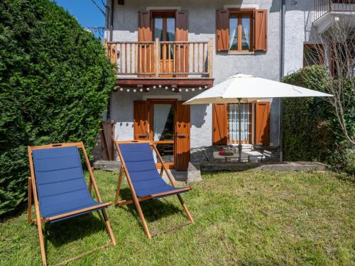 zwei Stühle und ein Regenschirm vor einem Haus in der Unterkunft Holiday Home Jouvenceaux by Interhome in Sauze dʼOulx