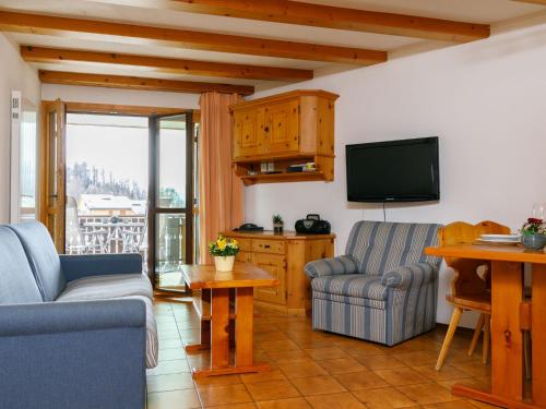 a living room with two chairs and a television at Apartment Residenza Chesa Margun 57-1 by Interhome in Surlej