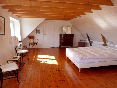 - une chambre mansardée avec un lit et des chaises dans l'établissement 473-Villa, 100m du GR34 Superbe vue mer, à Esquibien
