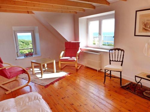 - un salon avec deux chaises et deux fenêtres dans l'établissement 473-Villa, 100m du GR34 Superbe vue mer, à Esquibien