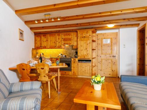 uma cozinha com armários de madeira e uma mesa num quarto em Apartment Residenza Chesa Margun 57-1 by Interhome em Surlej