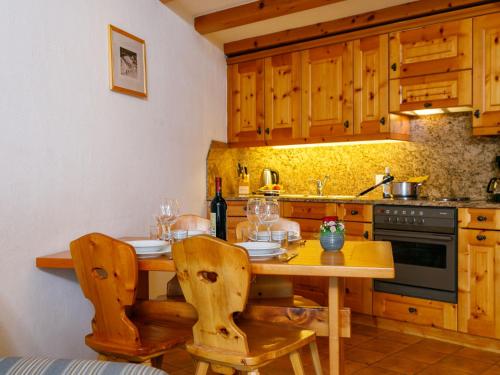 a kitchen with a wooden table with chairs and a sink at Apartment Residenza Chesa Margun 57-1 by Interhome in Surlej