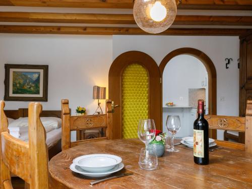 a dining room table with a bottle of wine on it at Apartment Residenza Chesa Margun 35-7 by Interhome in Surlej