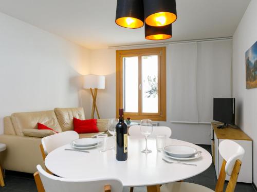 a living room with a white table with a wine bottle on it at Apartment Residenza Chesa Margun 33-2 by Interhome in Surlej