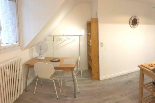 a dining room with a table and chairs and a staircase at Studio CLOCK in Chambéry