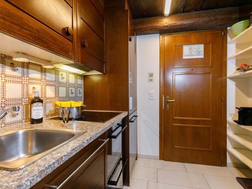 a kitchen with a sink and a wooden door at Apartment Residenza Chesa Margun 47-2 by Interhome in Surlej