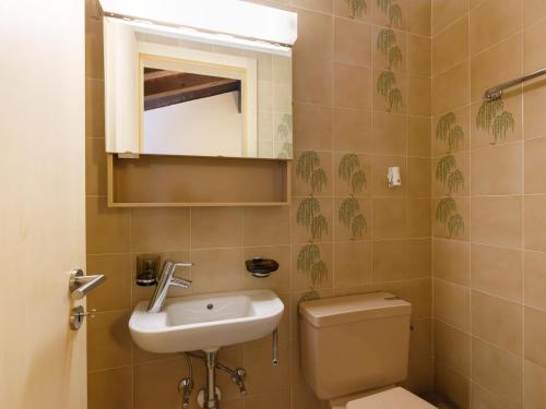 a bathroom with a sink and a toilet and a mirror at Apartment Residenza Chesa Margun 47-2 by Interhome in Surlej
