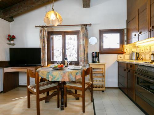een keuken met een tafel en een aantal stoelen en een tafel en een keuken bij Apartment Residenza Chesa Margun 710-4 by Interhome in Surlej