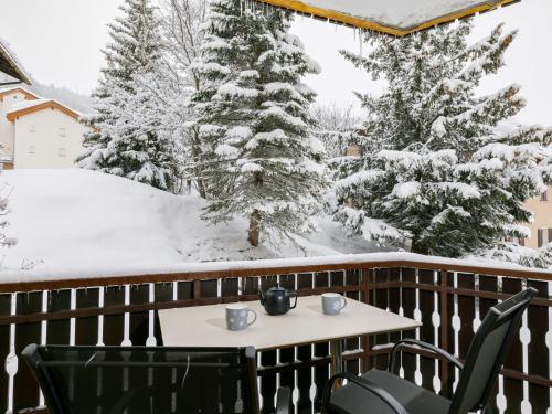ズルレイにあるApartment Residenza Chesa Margun 35-6 by Interhomeの雪に覆われた木々が植わるバルコニー(テーブル、椅子付)
