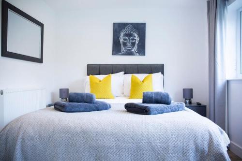 a bedroom with a large bed with blue pillows at Bridge House Apartments - Free Parking in Shottery