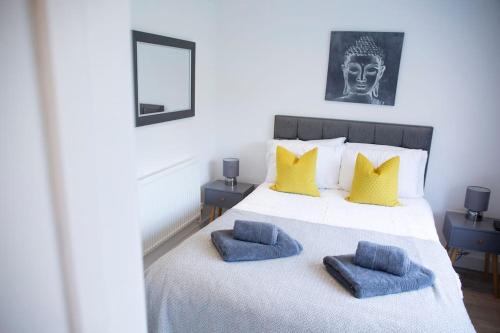 a bedroom with a bed with two blue pillows on it at Bridge House Apartments - Free Parking in Shottery